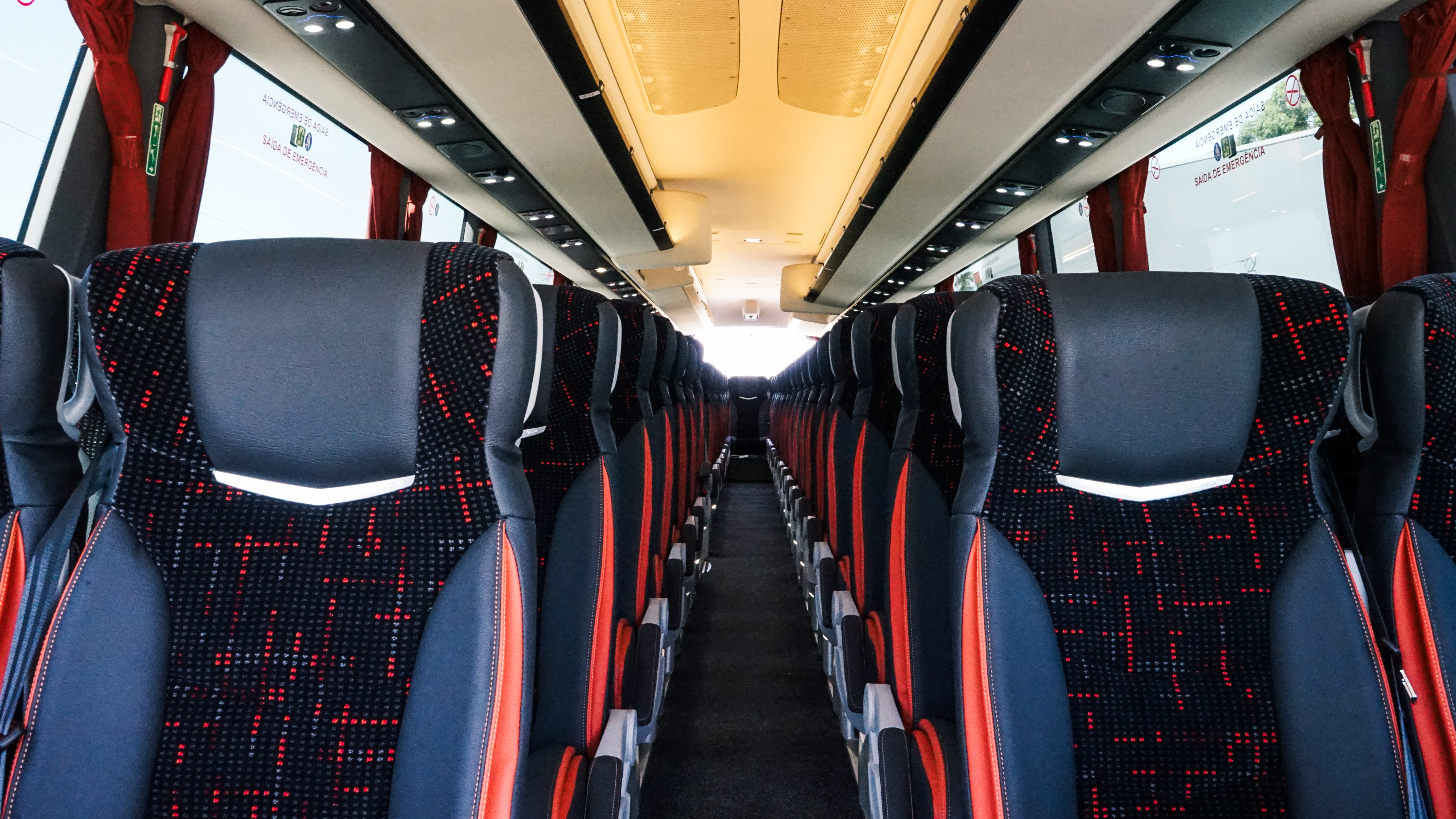 Interior de um autocarro MOVIG com filas de bancos e corredor central
