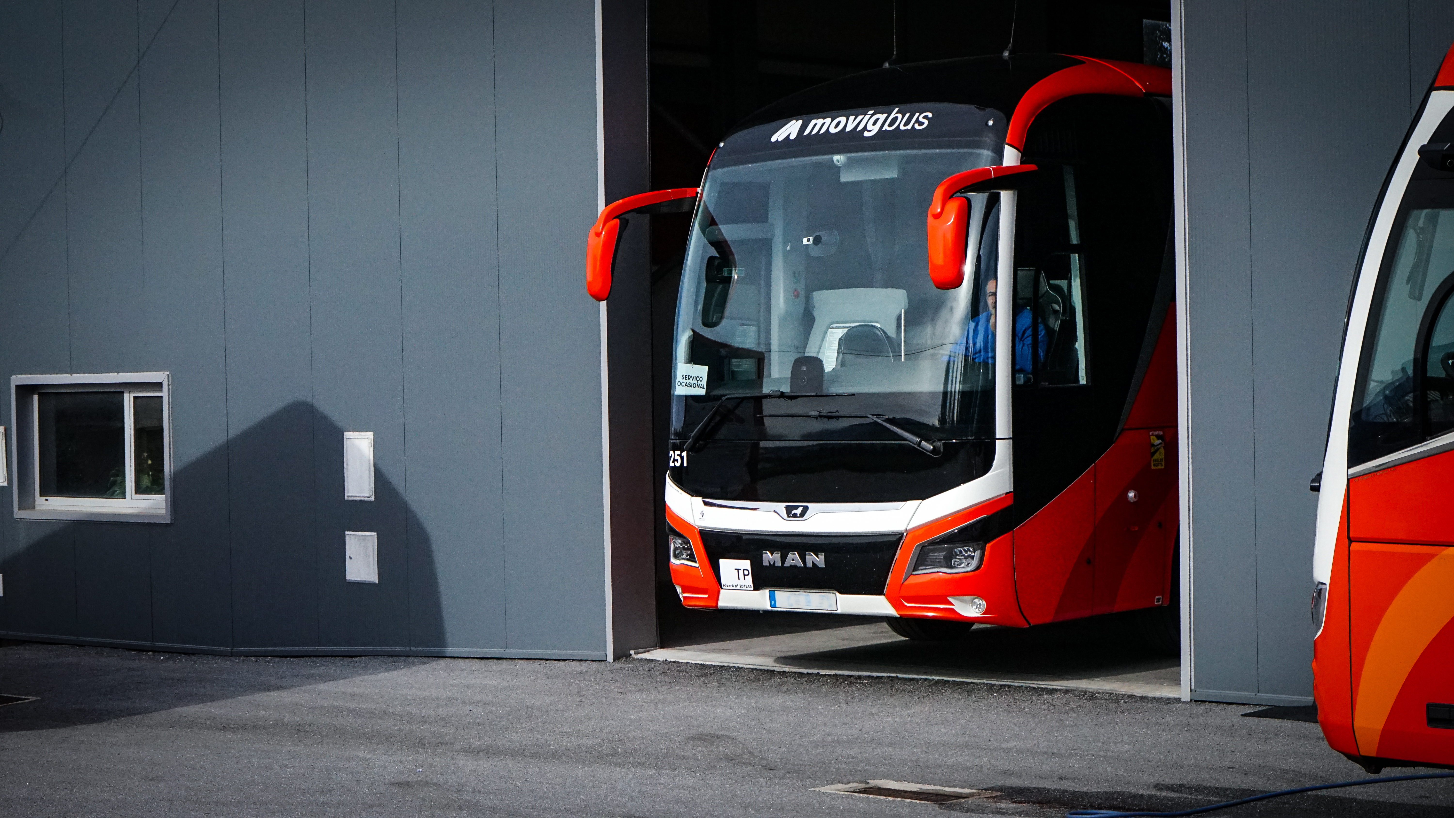 Autocarro MOVIG nas instalações da empresa, com um segundo autocarro ao lado