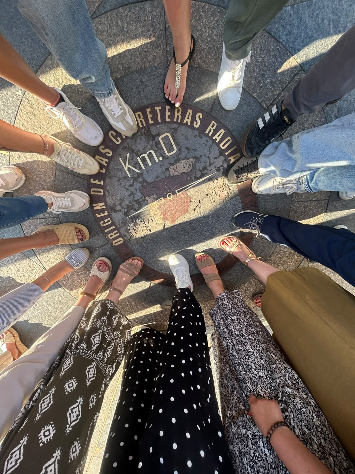 Professores em círculo sobre a placa do Km 0, na Puerta del Sol