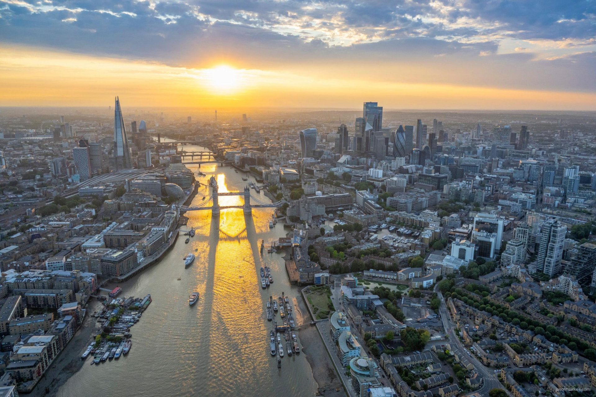 Vista aérea de Londres ao pôr do sol, com a Tower Bridge sobre o Tamisa